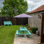Enclosed garden for the Stable Cottage with picnic bench and parasol
